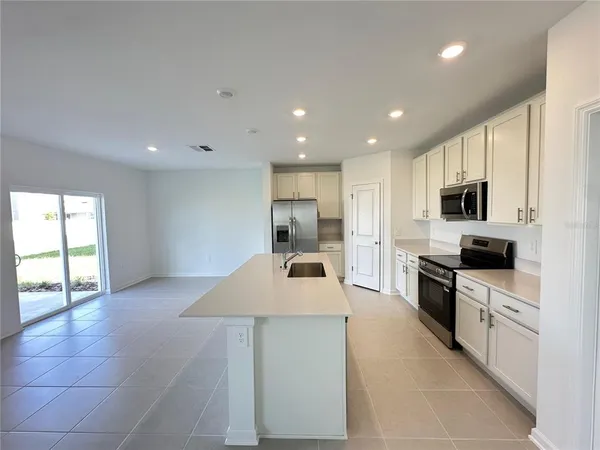 a large kitchen with kitchen island a sink stainless steel appliances and cabinets