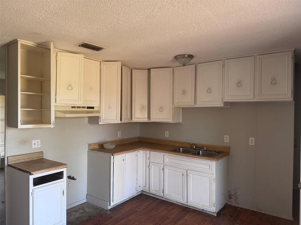 2112 Sunset Drive Brookston, TX 75421 - Photo 3 of 8 a kitchen with granite countertop white cabinets and white appliances