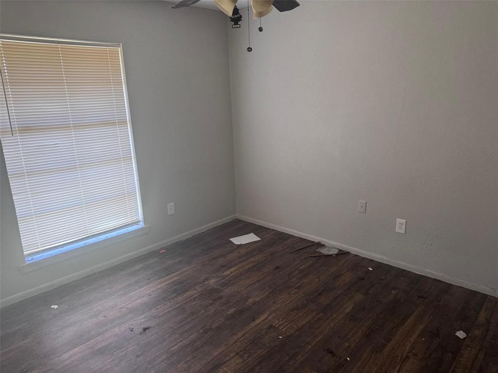 2112 Sunset Drive Brookston, TX 75421 - Photo 5 of 8 an empty room with wooden floor and windows
