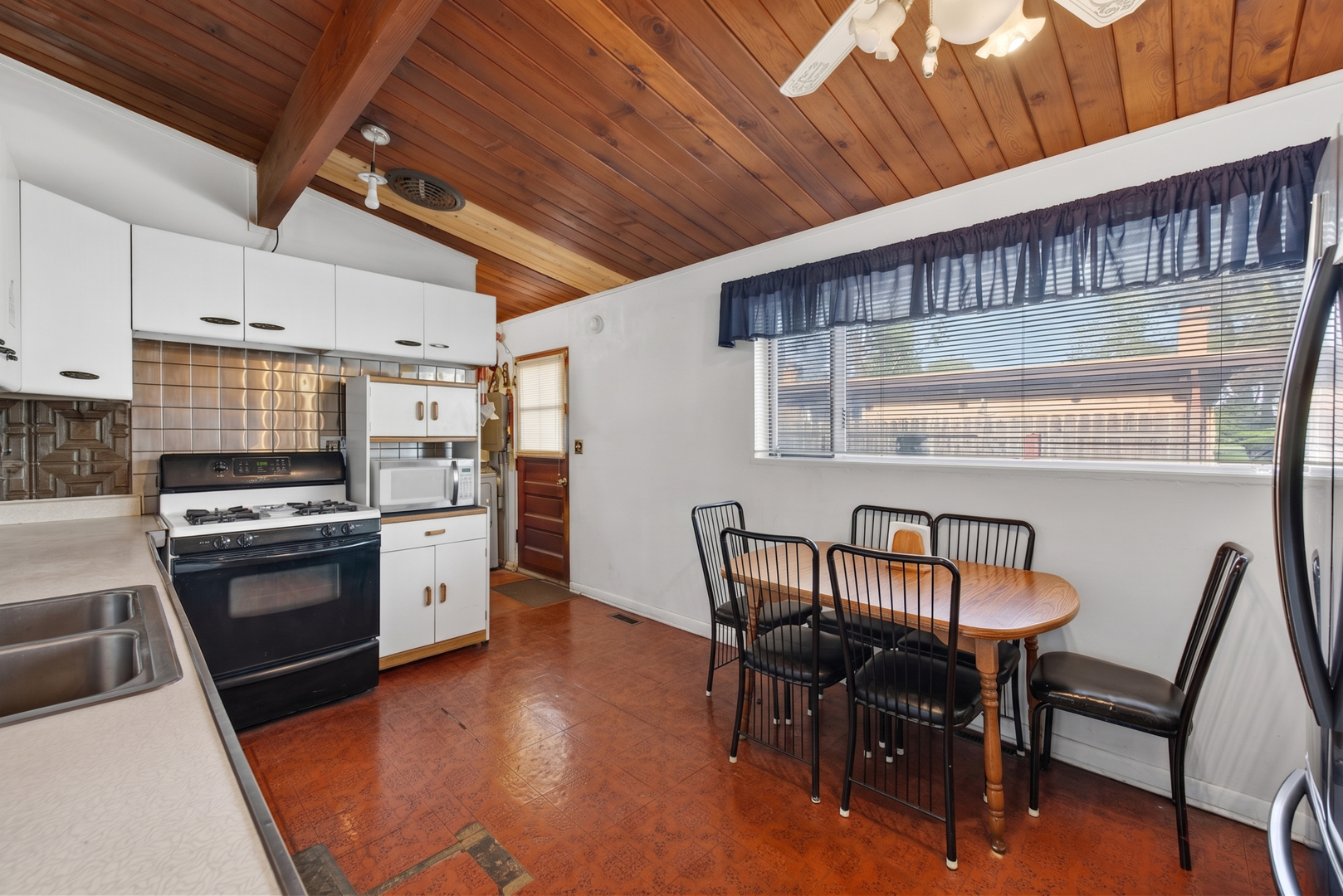 308 Natoma Avenue Addison, IL 60101 - Photo 3 of 21 a kitchen with stainless steel appliances granite countertop a stove a refrigerator a dining table and chairs with wooden floor