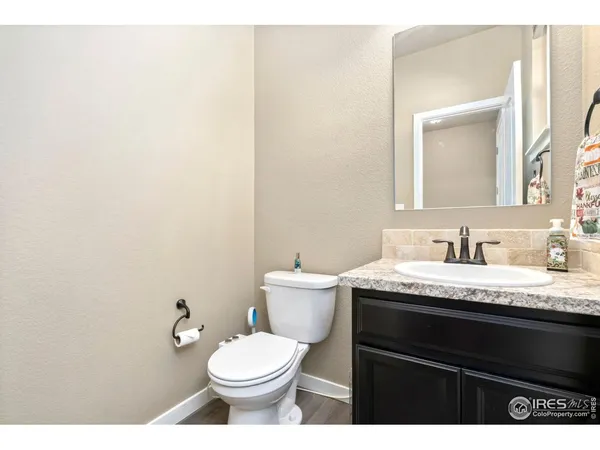 a bathroom with a granite countertop toilet sink and mirror