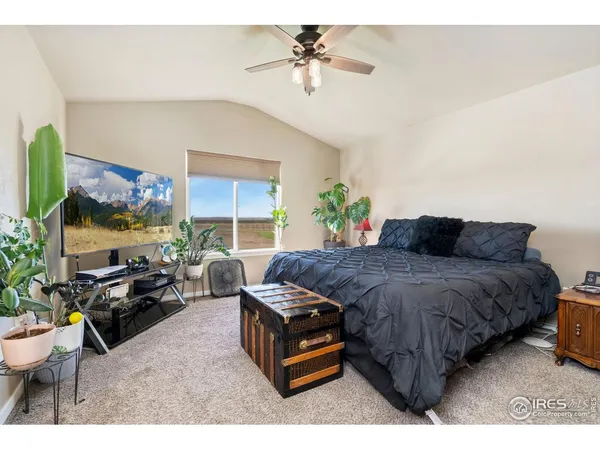a spacious bedroom with a bed a couch and a chandelier