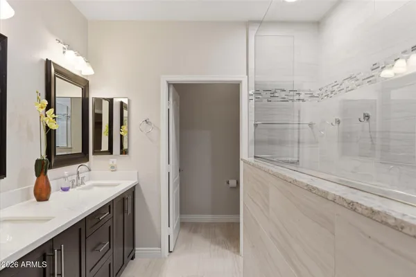 a bathroom with a double vanity sink mirror and shower