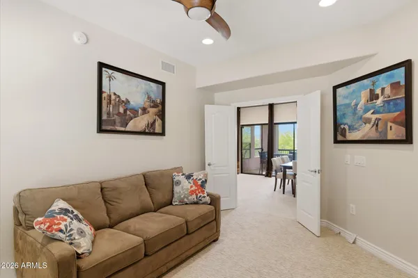a living room with furniture and a painting on the wall