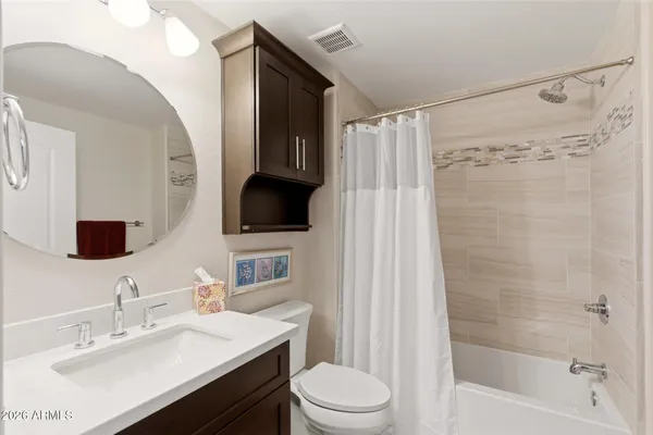 a bathroom with a sink a toilet a mirror and shower