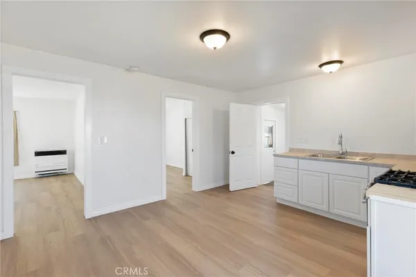 a view of a kitchen with a sink and dishwasher with wooden floor