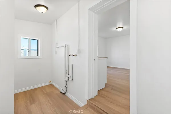 a view of a room with wooden floor and a bathroom