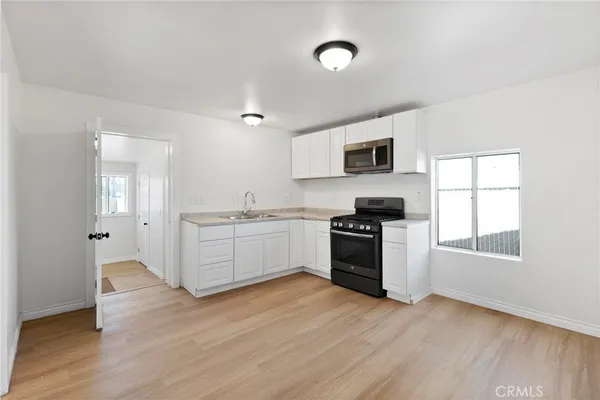 a kitchen with granite countertop a stove top oven and sink