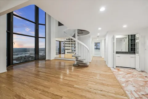 a view of empty room with wooden floor and floor to ceiling window