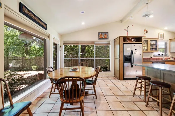 a dining room with furniture and large windows