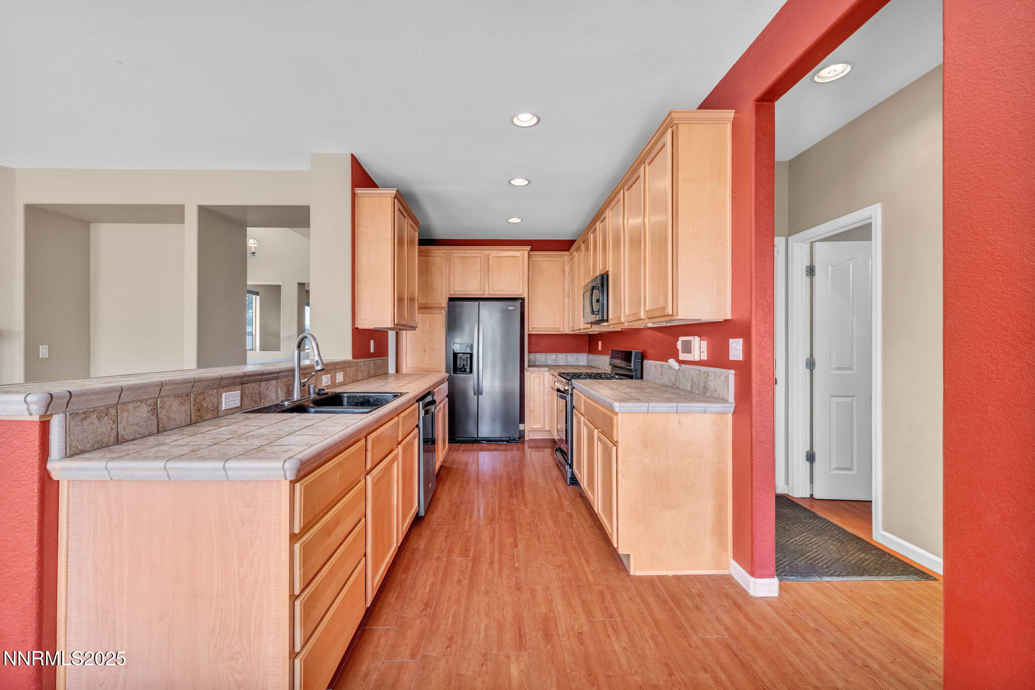 420 Miesque Court Reno, NV 89521 - Photo 15 of 43 a kitchen with stainless steel appliances granite countertop wooden cabinets a sink a stove a refrigerator and island with wooden floor