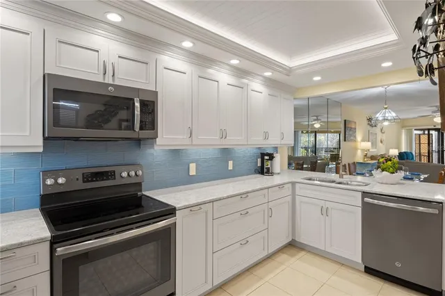 a kitchen with appliances a sink and cabinets