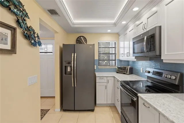 a kitchen with stainless steel appliances granite countertop a refrigerator a sink a stove and cabinets