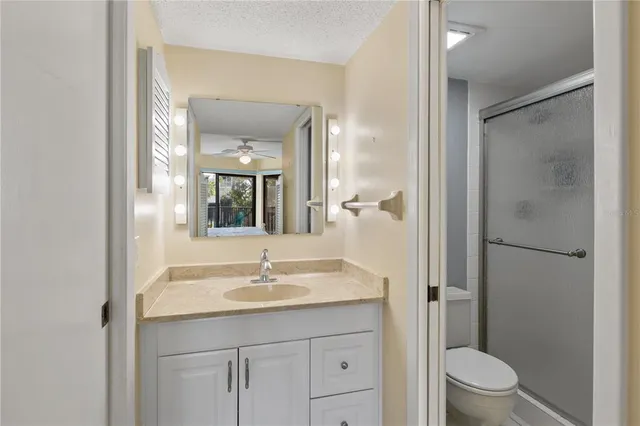 a bathroom with a sink a toilet a shower and a mirror