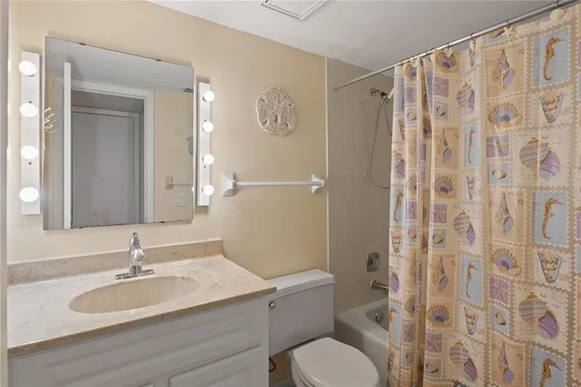 a bathroom with a granite countertop sink toilet a mirror and shower