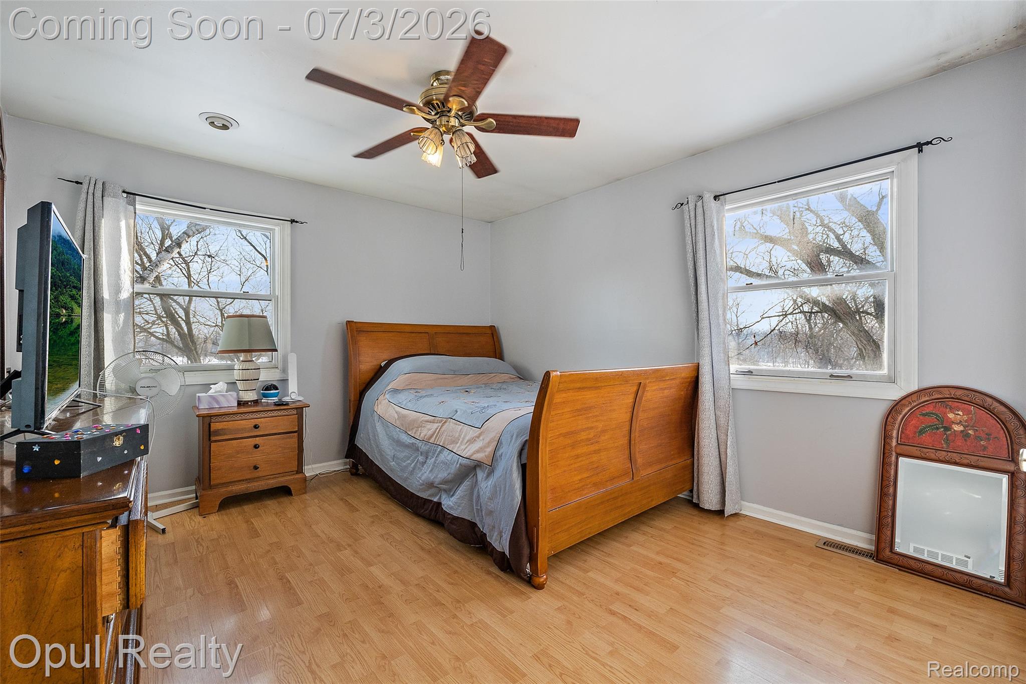 8855 Gross Road Dexter, MI 48130 - Photo 47 of 53 Bright room featuring two windows, wood-finish flooring, a ceiling fan, and light gray wall paint
