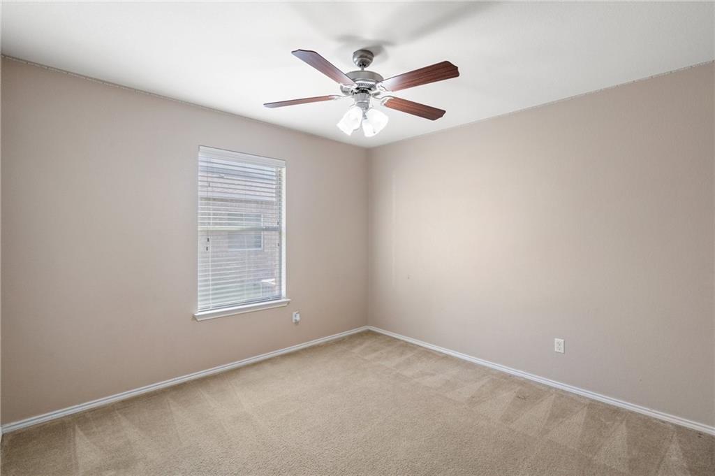 20224 Merlin Falcon Trail Pflugerville, TX 78660 - Photo 30 of 40 A well-lit bedroom provides comfort with soft carpet flooring and a refreshing ceiling fan.