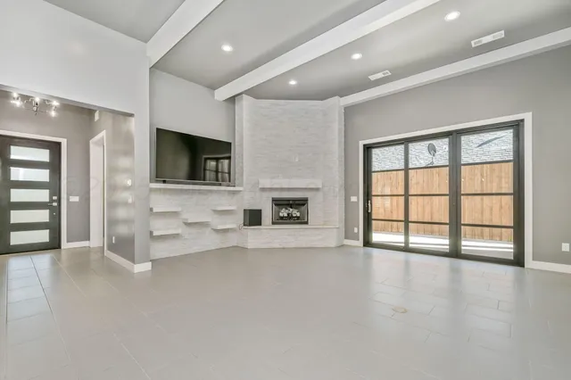 a view of an empty room with a fireplace and a window