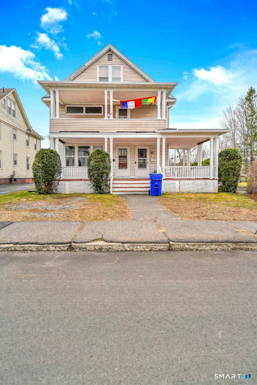 a front view of house with yard and trees in the background