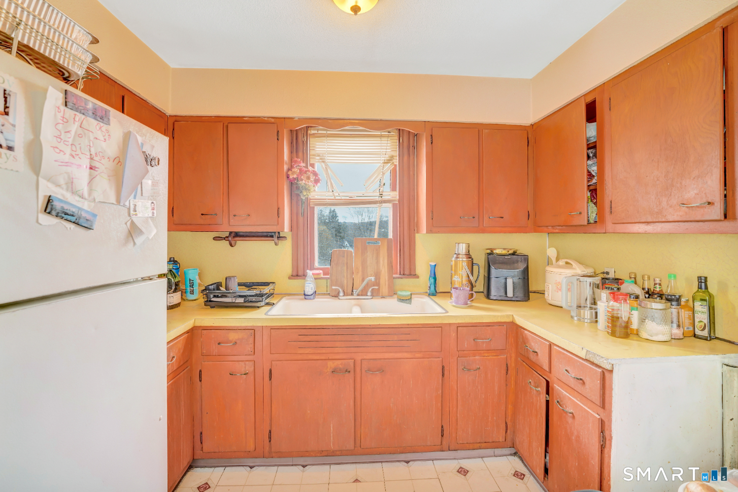 43 Evans Street Torrington, CT 06790 - Photo 7 of 17 a kitchen with a refrigerator a stove a sink dishwasher and wooden cabinets with wooden floor