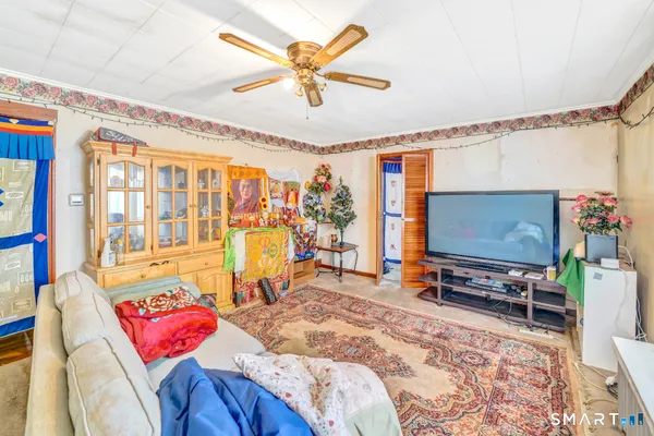 a living room with furniture a flat screen tv and a large window