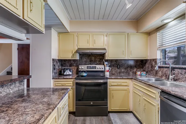 a kitchen with stainless steel appliances granite countertop a stove a sink and a microwave