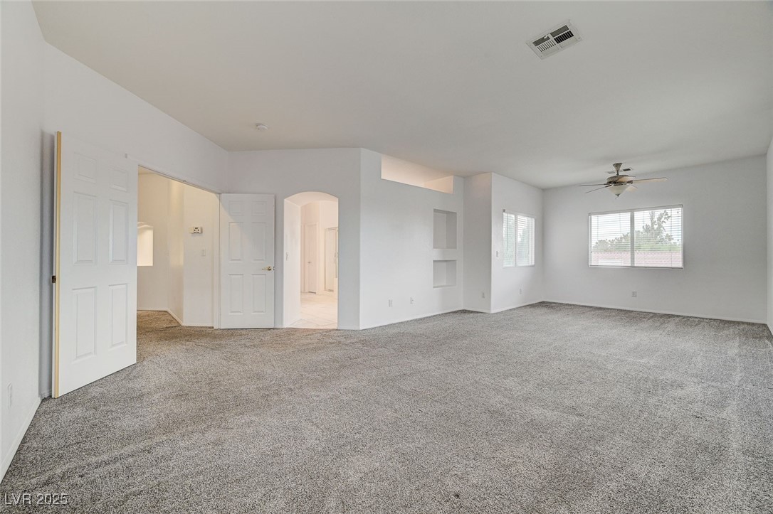 6012 Prospector Trail Las Vegas, NV 89118 - Photo 37 of 73 Unfurnished living room with carpet, arched walkways, and ceiling fan