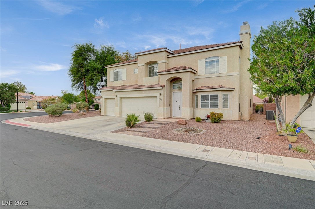 6012 Prospector Trail Las Vegas, NV 89118 - Photo 4 of 73 Mediterranean / spanish house featuring a chimney, a garage, concrete driveway, stucco siding, and a tiled roof