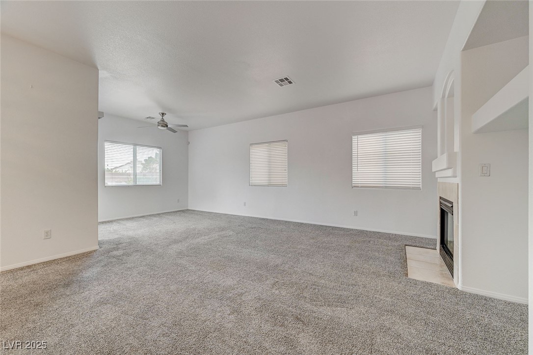 6012 Prospector Trail Las Vegas, NV 89118 - Photo 10 of 73 Unfurnished living room with light colored carpet and a tiled fireplace
