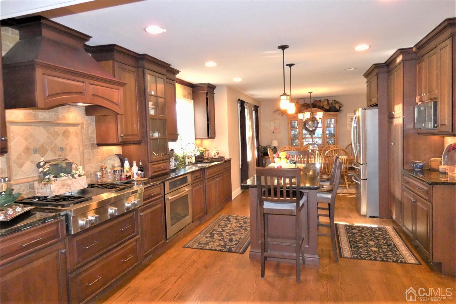 14 Apple Tree Road Flemington, NJ 08822 - Photo 9 of 33 a kitchen with stainless steel appliances kitchen island granite countertop a refrigerator a stove a sink a dining table and chairs with wooden floor