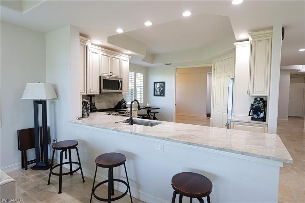 5963 Trophy Drive, Unit 2002 Naples, FL 34110 - Photo 12 of 33 a room with sink and a large mirror with wooden floor