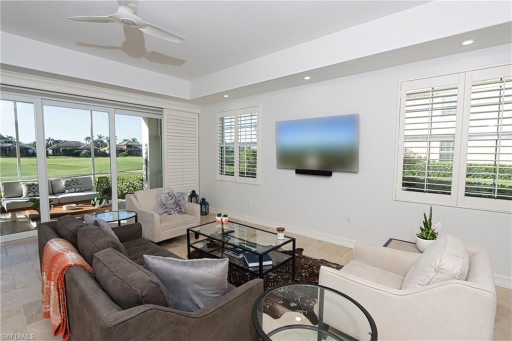 5963 Trophy Drive, Unit 2002 Naples, FL 34110 - Photo 5 of 33 a living room with furniture tv and large window