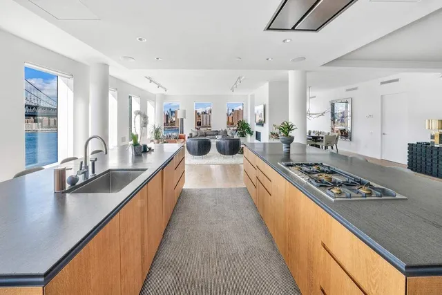 a large living room with stainless steel appliances granite countertop a couch and a wooden floor