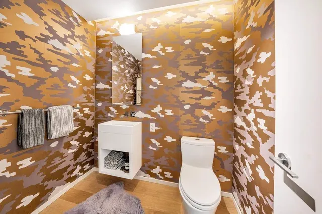 a bathroom with a toilet sink and mirror