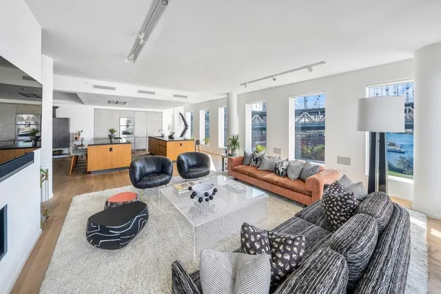 a living room with furniture and a dining table with wooden floor