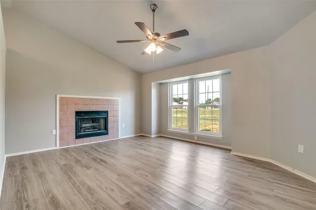 a view of an empty room with a fireplace and a window