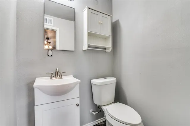a white toilet sitting next to a bathroom sink