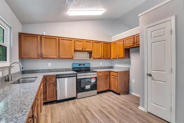 a kitchen with stainless steel appliances granite countertop a sink stove and refrigerator