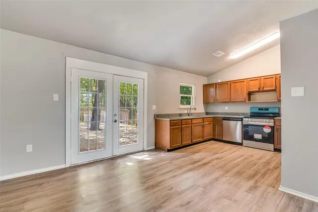 a kitchen with stainless steel appliances kitchen island a large counter top and a wooden floors
