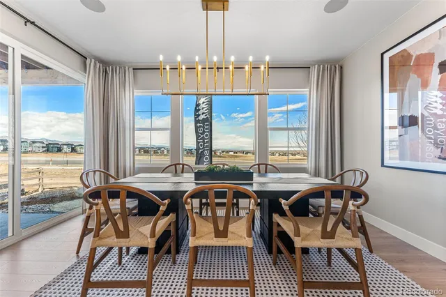 a kitchen with stainless steel appliances kitchen island granite countertop a dining table chairs and white cabinets