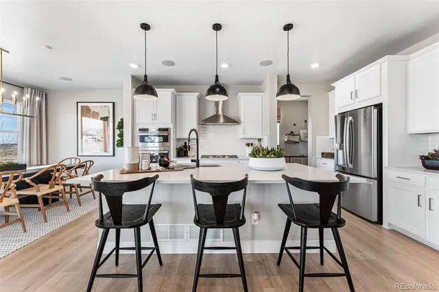 a kitchen with sink stove and refrigerator