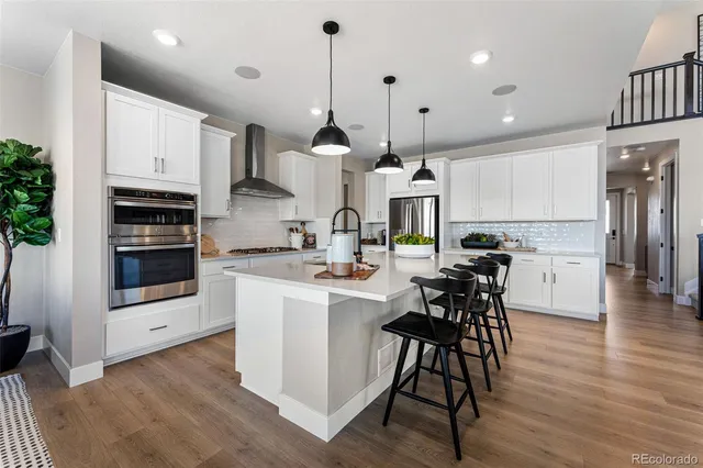 a kitchen with stainless steel appliances kitchen island a large counter space a sink and a refrigerator