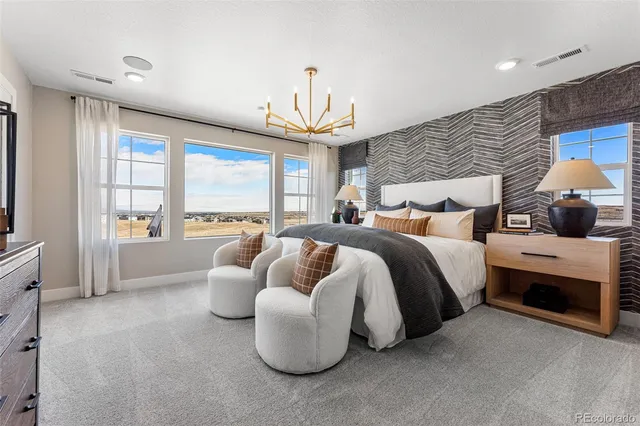 a spacious bedroom with a bed and a dresser with mirror