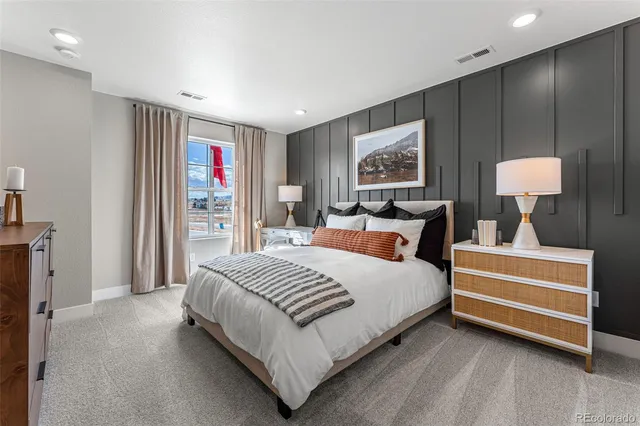 a bedroom with furniture and a large window