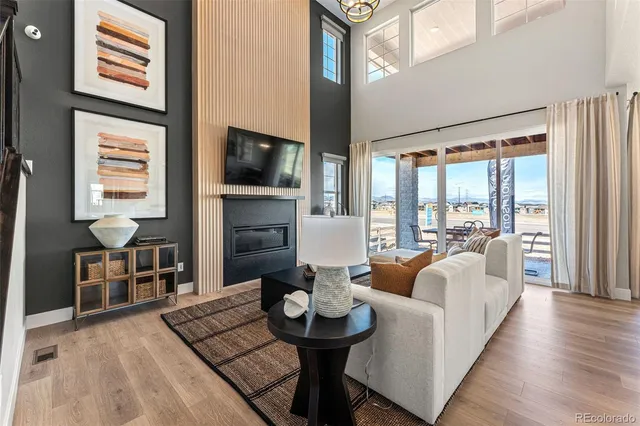 a living room with fireplace furniture and a large window