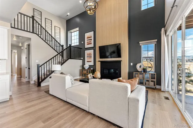 a view of a dining room with furniture a chandelier and wooden floor