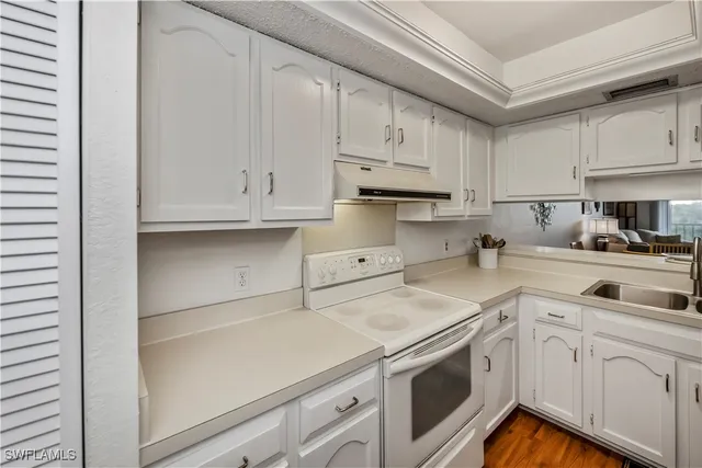 a kitchen with white cabinets and white appliances