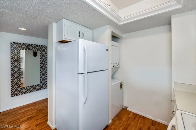 a white refrigerator freezer and a wooden floor