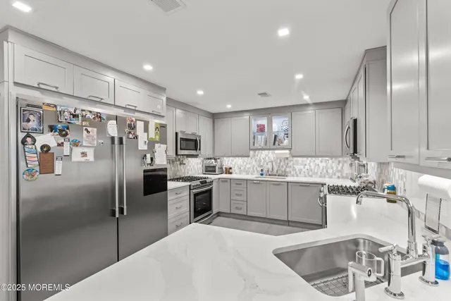 a kitchen with stainless steel appliances granite countertop a refrigerator and a sink