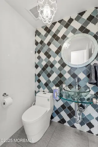 a bathroom with a sink mirror and a toilet